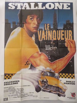 On voit l'affiche du film « Le Vainqueur ».