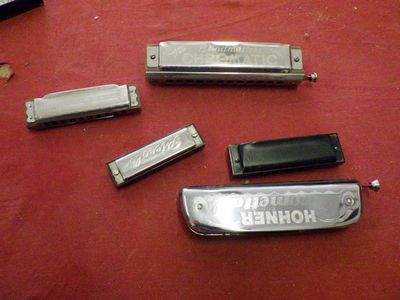 four harmonicas sitting on a table with a red table cloth
