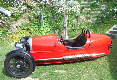 a red car that is sitting in the grass