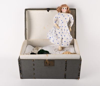 a doll that is sitting inside of a suitcase
