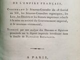 Un vieux livre est ouvert sur une table devant une fenêtre.