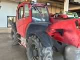 a large red tractor parked in a garage