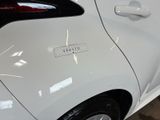 a close up of a white car with a sticker on it