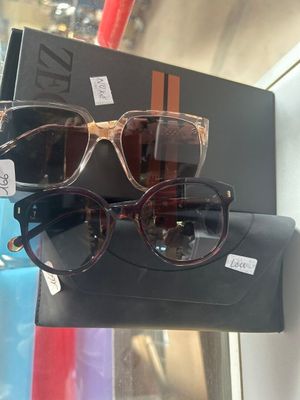 une paire de lunettes de soleil exposée dans la vitrine d'un magasin, accompagnée d'un étui