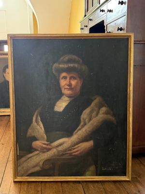 portrait d'une femme portant une étole en fourrure, assise sur une chaise dans une pièce