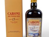 a bottle of caroni rum next to a cardboard box
