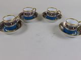 four cups and saucers are sitting on a white table