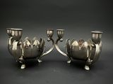 paire de bougeoirs plaqués argent sur un socle, sur fond noir