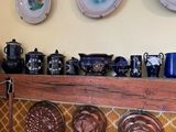 de nombreuses assiettes et tasses posées sur une étagère dans une pièce