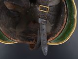 an old helmet with a leather strap and a buckle on it