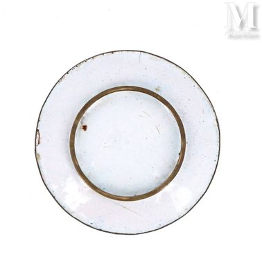 une assiette blanche à bord doré posée sur une table blanche