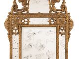 an ornately carved mirror with a gold frame on a white background