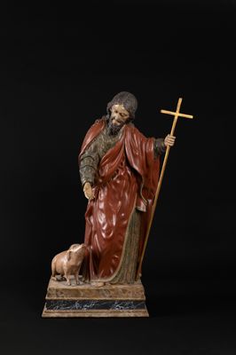 a statue of a man with a dog and a cross