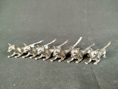 cinq figurines de chats en argent sur un fond noir