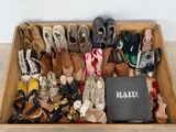 many pairs of shoes in a wooden box on the floor