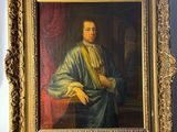 portrait of a man in a blue robe in a gold frame