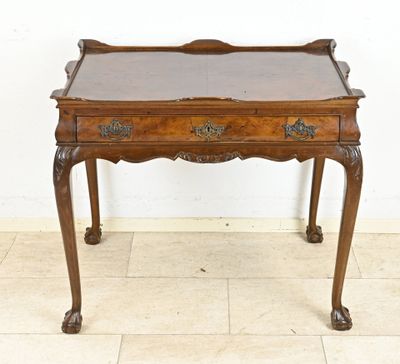 an old wooden desk with a glass top on a tiled floor