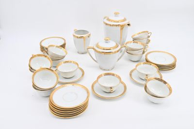 a lot of white and gold dishes and cups on the table