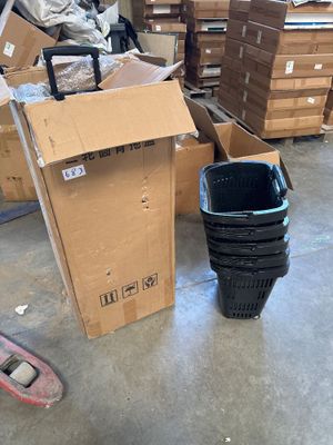 a pile of boxes and a trash can in a warehouse