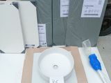 a white bowl sitting on top of a table next to some boxes