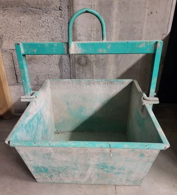 un seau bleu muni d'une poignée, posé par terre
