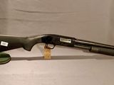 un vieux fusil de chasse posé sur un support en bois, sur fond blanc