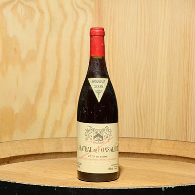 a bottle of wine sitting on top of a barrel