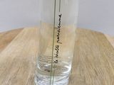 a glass vase with a flower in it sitting on a table