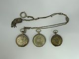 three antique pocket watches and a chain with a bird on it