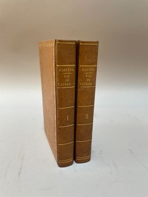 deux livres bruns posés l'un sur l'autre sur une surface blanche