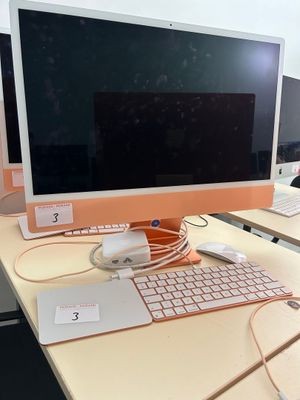 a desk with two computers and a keyboard on it