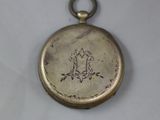 a small gold pocket watch on a white surface