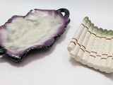two pieces of pottery sitting on top of a table next to each other