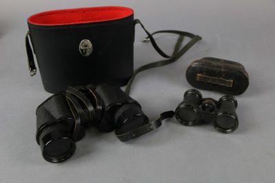 un sac noir muni d'une poignée rouge et d'une paire de jumelles