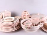 beaucoup d'assiettes et de tasses roses sur la table