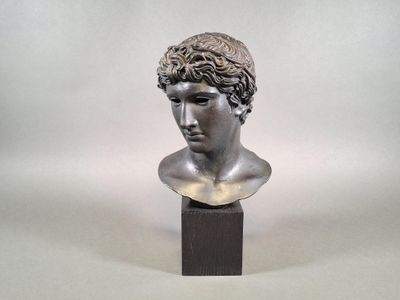 bust of a young man with curly hair on a wooden base