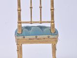 a gold chair with a blue cushion on it