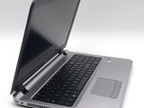 a silver laptop with a black keyboard on a white surface