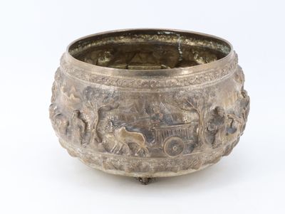 a silver bowl with animals on it on a white surface