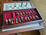 a wooden box with chess pieces in it on a table