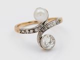 un gros plan d'une bague ornée d'une perle et d'un diamant