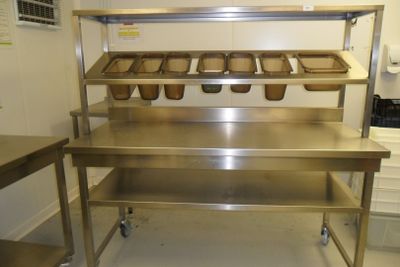 a large stainless steel table with trays of food on it