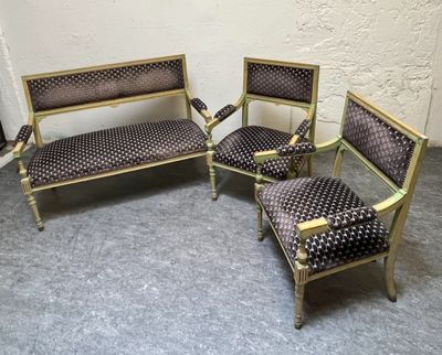 trois chaises et un canapé dans une pièce, avec un mur en arrière-plan