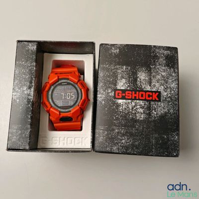 an orange watch in a box on a white surface