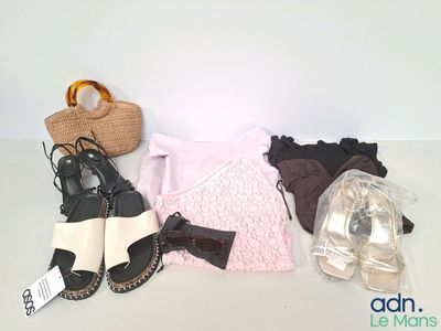 Plusieurs paires de chaussures, un sac à main et un sac à main sont posés sur une table