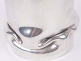 a close up of a silver cup on a white surface