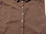 the shirt is brown and has buttons on the collar
