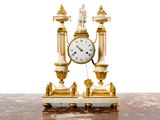 une horloge dorée et blanche posée sur une table en marbre