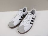 une paire de baskets blanches et noires posées sur une surface blanche