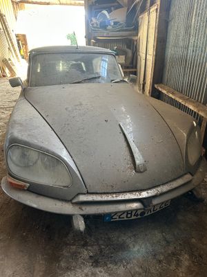 une voiture garée dans un garage, avec de la terre par terre